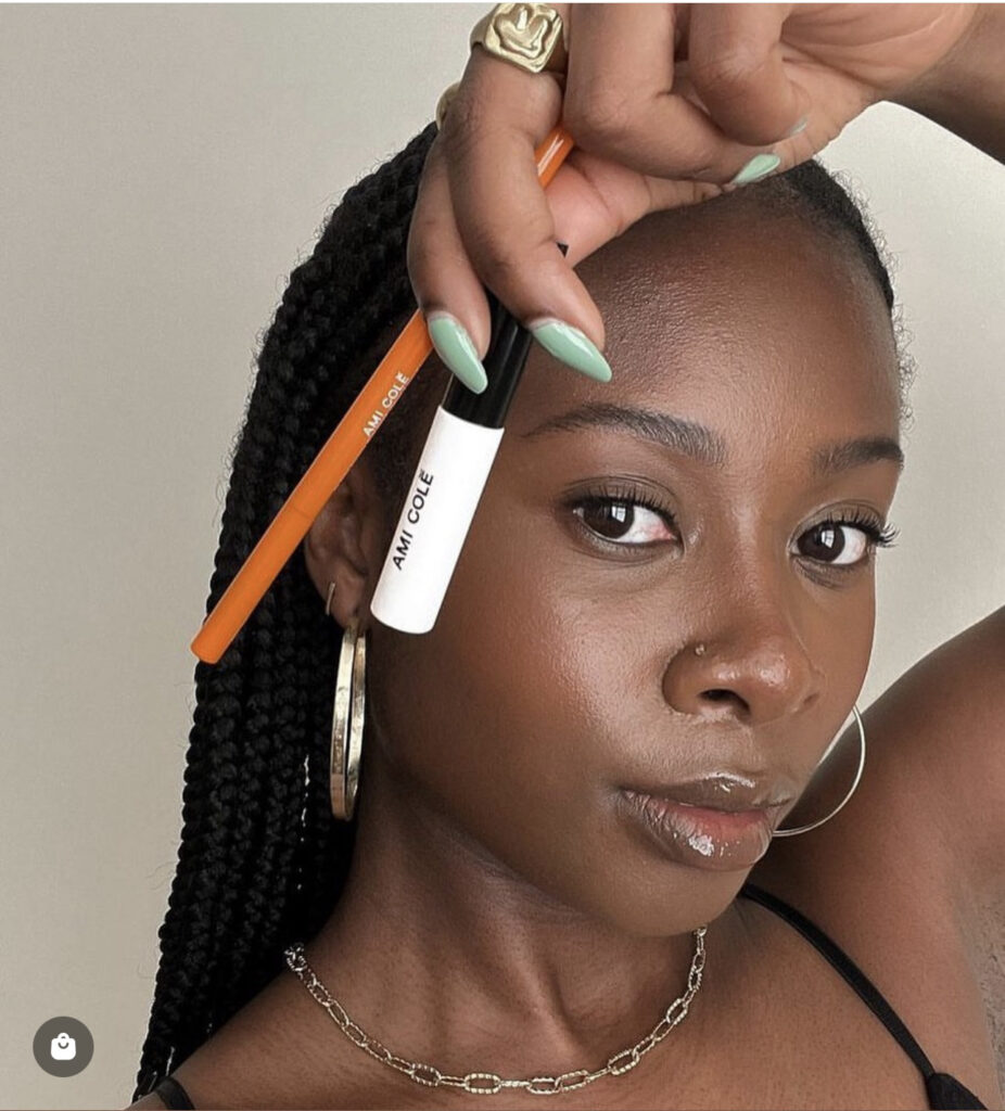 reef-friendly makeup Dark skinned Black woman holding white and orange makeup containers